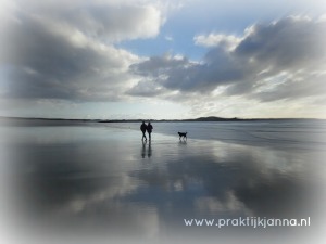 Een koppel wandelt op een leeg strand